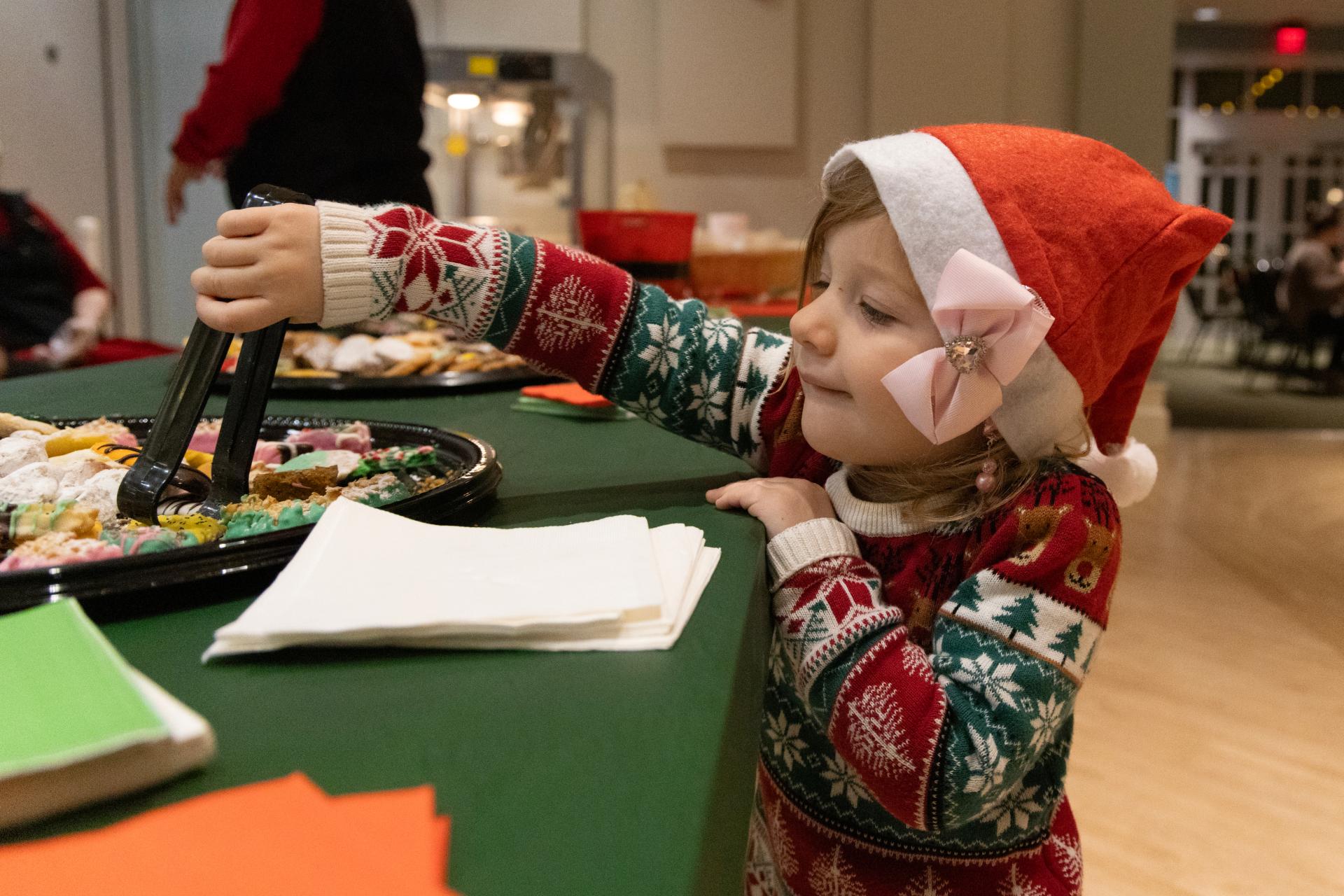 Festive kid grabbing a cookie